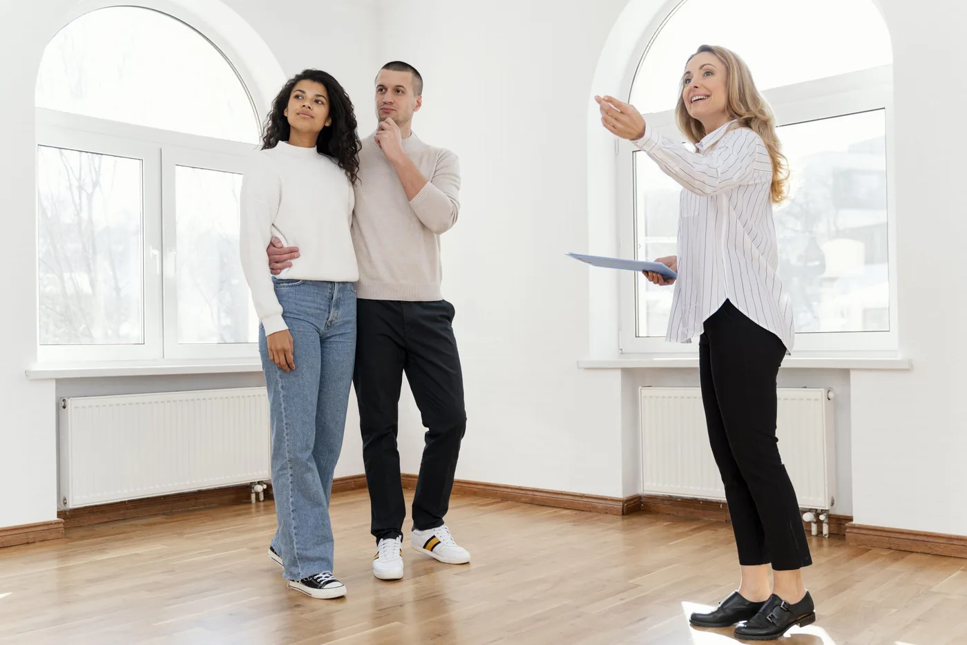 female-realtor-showing-young-couple-new-house-scaled